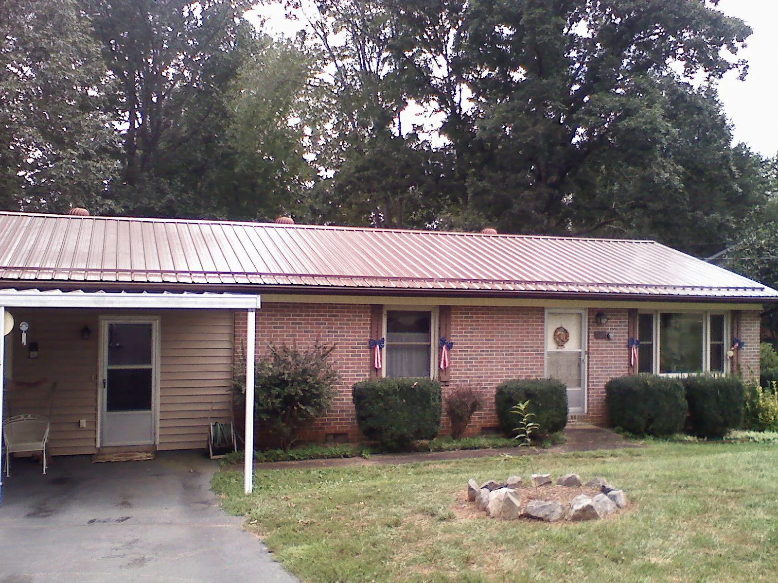 Bronze metal roof and carport on a brick ranch home — Roof Repair work by our crew in Leasburg